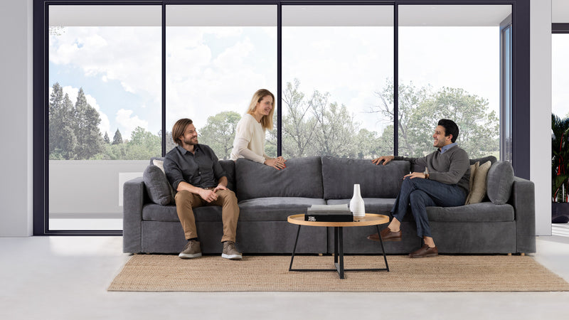 Friends sitting on a modular couch in a modern living room.
