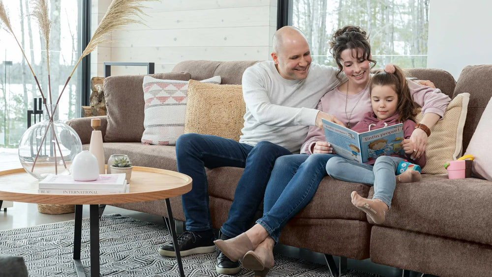 A family reading a book on a couch